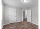 Neutral bedroom boasts wood-look floors, fresh paint, and an adjoining doorway to a walk-in closet for ample storage at 120 Cabrita Ct, Holly Springs, NC 27540