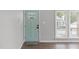 Light green front door and a window in the front entryway with wood-look flooring at 120 Cabrita Ct, Holly Springs, NC 27540