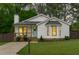 Charming white cottage-style home featuring a cozy porch and well-manicured lawn at 120 Cabrita Ct, Holly Springs, NC 27540