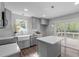 Charming kitchen features grey cabinetry, a farmhouse sink, an island, and stainless appliances at 120 Cabrita Ct, Holly Springs, NC 27540