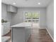 Bright kitchen features an island, stainless appliances, and sliding glass door to the deck at 120 Cabrita Ct, Holly Springs, NC 27540