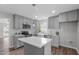 Modern kitchen boasts grey cabinetry, stainless appliances, and an island perfect for entertaining at 120 Cabrita Ct, Holly Springs, NC 27540