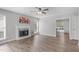 Bright living room featuring wood-look floors, a fireplace, and an open doorway at 120 Cabrita Ct, Holly Springs, NC 27540