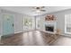 Living room with wood-look flooring, a ceiling fan, a fireplace, and lots of natural light at 120 Cabrita Ct, Holly Springs, NC 27540