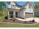 Charming two-story home featuring manicured lawn, well-kept flowerbeds, and a covered front porch at 1211 Yellow Wood Dr, Mebane, NC 27302