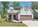 Charming two-story home featuring manicured lawn, well-kept flowerbeds, and a two-car garage at 1211 Yellow Wood Dr, Mebane, NC 27302