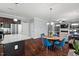 Open-concept kitchen/dining room featuring stainless appliances, hardwood floors and blue chairs at 1211 Yellow Wood Dr, Mebane, NC 27302