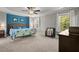 Spacious main bedroom with a blue accent wall, tray ceiling, fan, and carpeted floors at 1211 Yellow Wood Dr, Mebane, NC 27302