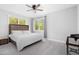 This bedroom features a ceiling fan, carpeted floor and large windows providing an abundance of natural light at 1213 Rocky Point Ln, Durham, NC 27712