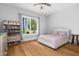 Cozy bedroom with a white bed, wood floor, bookshelf and window with natural view at 1213 Rocky Point Ln, Durham, NC 27712