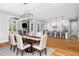 Bright dining room featuring hardwood floors, a modern chandelier, and an open floor plan with a view into the kitchen at 1213 Rocky Point Ln, Durham, NC 27712