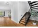 Bright entryway with modern stairs, hardwood floors, and open access to the kitchen and living spaces at 1213 Rocky Point Ln, Durham, NC 27712