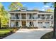 Charming two-story home boasts a double-decker porch and well-manicured lawn on a sunny day at 1213 Rocky Point Ln, Durham, NC 27712