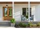 Inviting front porch with stone steps, rocking chairs and a beautiful wood door at 1213 Rocky Point Ln, Durham, NC 27712