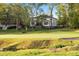 View of backyard backing up to lush golf course with mature hardwoods, offering a serene and picturesque setting at 1213 Rocky Point Ln, Durham, NC 27712