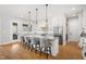 A modern kitchen with white cabinetry, stainless steel appliances, a large island with seating, and hardwood floors at 1213 Rocky Point Ln, Durham, NC 27712