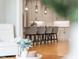 Modern kitchen area with gray barstools, white cabinets, granite counters, and stainless appliances viewed from living space at 1213 Rocky Point Ln, Durham, NC 27712