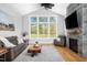 Living room features a stone fireplace, large windows overlooking the yard, and comfortable seating at 1213 Rocky Point Ln, Durham, NC 27712