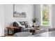 Comfortable living room with a leather sofa, wood furniture, and a large window with natural light at 1213 Rocky Point Ln, Durham, NC 27712