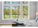 Relaxing bedroom featuring a large window overlooking lush landscaping and a rustic wood bed frame at 1213 Rocky Point Ln, Durham, NC 27712