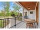 Scenic porch with views of the yard, featuring a wood ceiling, wood table, and white columns at 1213 Rocky Point Ln, Durham, NC 27712