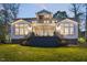 Home's rear exterior with a large deck, covered patio, and large windows overlooking the backyard at 1213 Rocky Point Ln, Durham, NC 27712