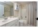 Bathroom features a shower-tub combo, white vanity, and neutral color palette at 1310 Country Club Dr, Durham, NC 27712