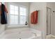 Relaxing bathroom featuring a large soaking tub with modern fixtures and frosted window at 1310 Country Club Dr, Durham, NC 27712