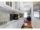 Hallway nook featuring white cabinetry and countertops with a view of the living room at 1310 Country Club Dr, Durham, NC 27712