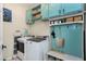 Convenient laundry room featuring updated washer and dryer, bright turquoise cabinets, and ample storage at 1310 Country Club Dr, Durham, NC 27712