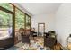 Cozy screened porch with a view of the woods features wood flooring and comfortable furniture arrangement at 1310 Country Club Dr, Durham, NC 27712