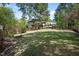 Expansive back yard featuring lush lawn, mature trees, and a charming pergola at 132 Wheatsbury Dr, Cary, NC 27513
