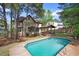 Spacious backyard featuring a large pool, outdoor lounge, and lush landscaping at 132 Wheatsbury Dr, Cary, NC 27513