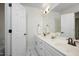 Bright bathroom featuring double sinks, white cabinets, and a large mirror at 132 Wheatsbury Dr, Cary, NC 27513