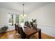 Dining room with hardwood floors, large window overlooking the backyard, and modern lighting at 132 Wheatsbury Dr, Cary, NC 27513