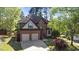An aerial view of a well-maintained brick home with a two-car garage surrounded by mature trees at 132 Wheatsbury Dr, Cary, NC 27513