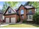Beautiful brick home boasts mature landscaping, attached two-car garage, and covered front porch at 132 Wheatsbury Dr, Cary, NC 27513