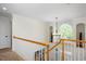Upstairs hallway with grand window, chandelier, and decorative railing at 132 Wheatsbury Dr, Cary, NC 27513