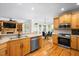 Open-concept kitchen with stainless steel appliances and adjacent dining area with backyard views at 132 Wheatsbury Dr, Cary, NC 27513