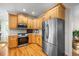 Well-lit kitchen featuring stainless steel appliances, light wood cabinets, and hardwood flooring at 132 Wheatsbury Dr, Cary, NC 27513