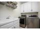 Well-equipped laundry room with a sink, storage cabinets, washer, and dryer at 132 Wheatsbury Dr, Cary, NC 27513