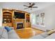 Inviting living room featuring custom built-ins, a fireplace, and a large comfortable sofa at 132 Wheatsbury Dr, Cary, NC 27513