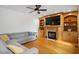 Comfortable living room features built-ins, a fireplace, hardwood floors, and a ceiling fan at 132 Wheatsbury Dr, Cary, NC 27513
