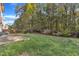 Large backyard featuring a well-maintained lawn, mature trees, and a wooden fence at 1323 Fairmont St, Durham, NC 27713