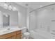 Bathroom with white tiled shower and bath and a wood vanity at 1323 Fairmont St, Durham, NC 27713