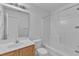 Bathroom with white tiled shower and bath and a wood vanity at 1323 Fairmont St, Durham, NC 27713