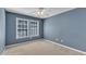 Bedroom with two windows, carpet, and painted blue walls at 1323 Fairmont St, Durham, NC 27713