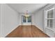 Bright dining room with wood floors, a modern chandelier, and a large window with neighborhood views at 1323 Fairmont St, Durham, NC 27713