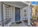 Inviting front porch with a dark blue door, trellis, and security system at 1323 Fairmont St, Durham, NC 27713