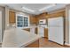 Well-lit kitchen features wood cabinets, laminate counters, white appliances, and wood flooring at 1323 Fairmont St, Durham, NC 27713